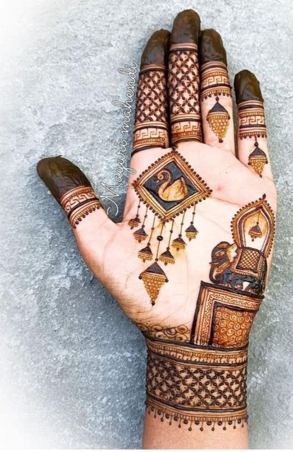 This may contain: a person's hand with henna tattoos on it