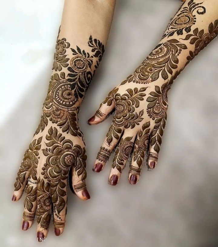 This may contain: two hands with henna tattoos on them