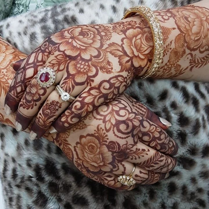 This may contain: two hands that are covered in henna