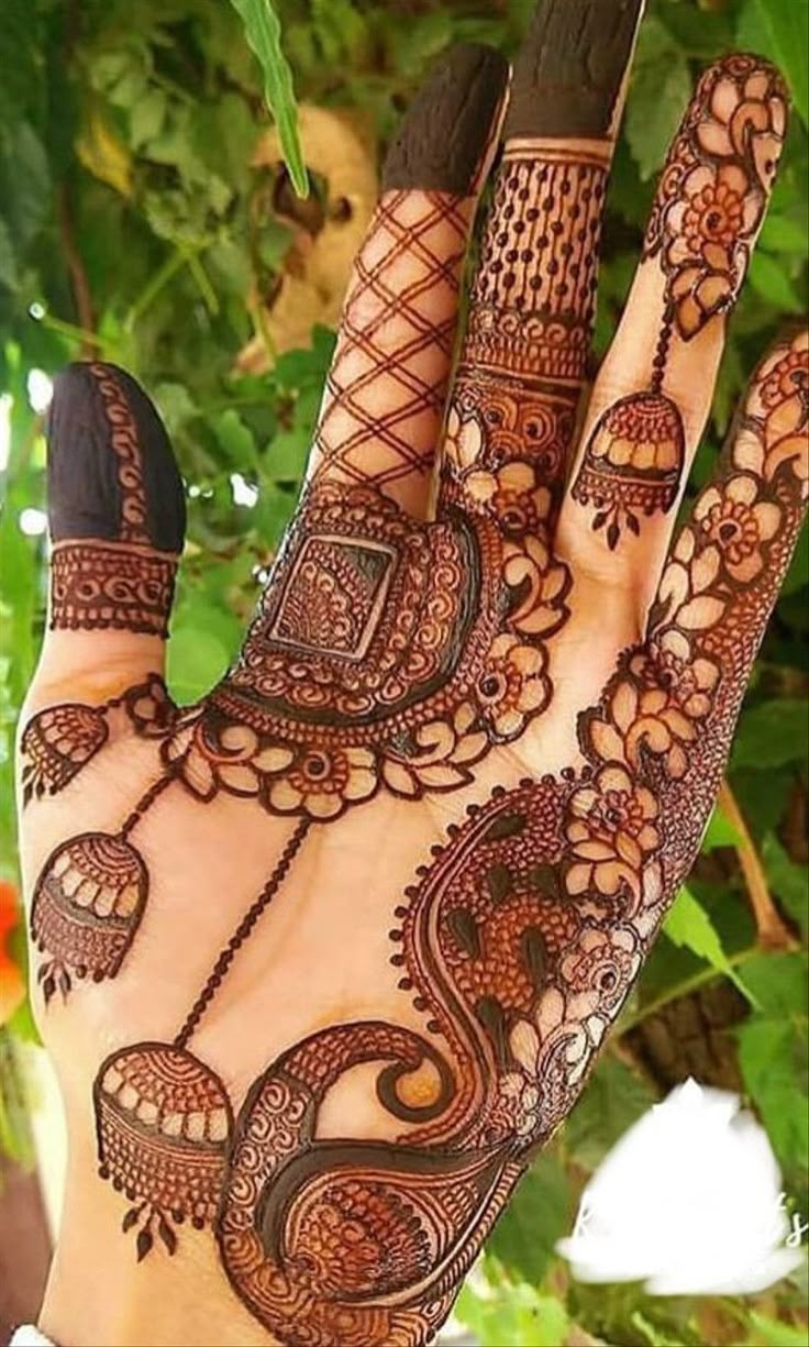 This may contain: a hand that has some henna on it