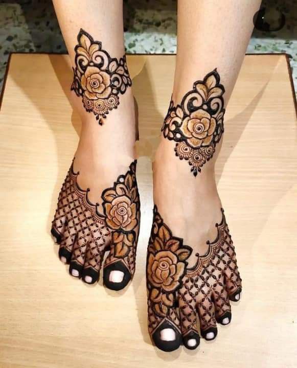 This may contain: a woman's feet with hennap and flowers on the toes, both decorated in