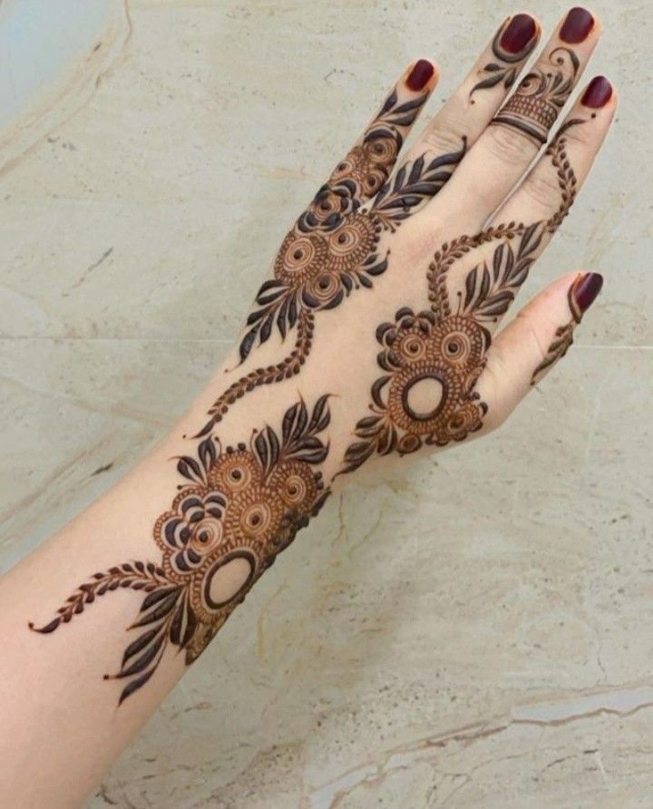 This may contain: a woman's hand is decorated with hennap and flower designs on it