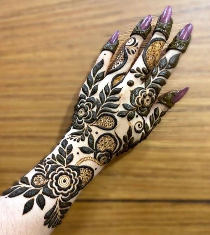 This may contain: a woman's hand is decorated with hennap and flower designs on it