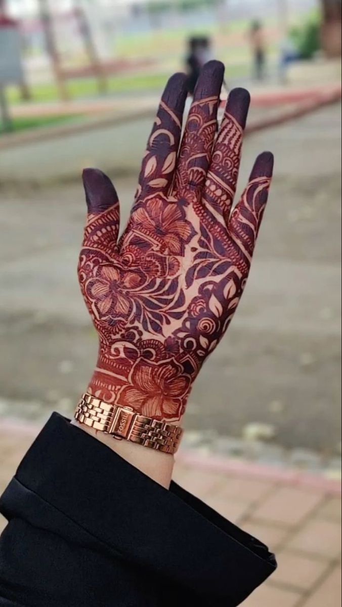 This may contain: a woman's hand with henna tattoos on it