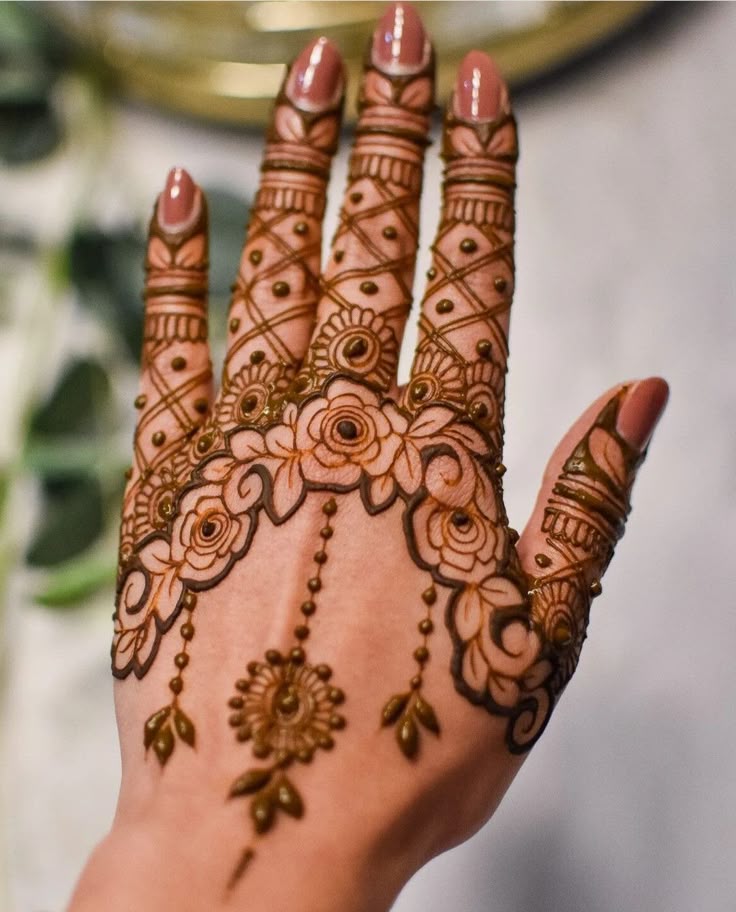 This may contain: a woman's hand is decorated with hennap and flowers on her hands