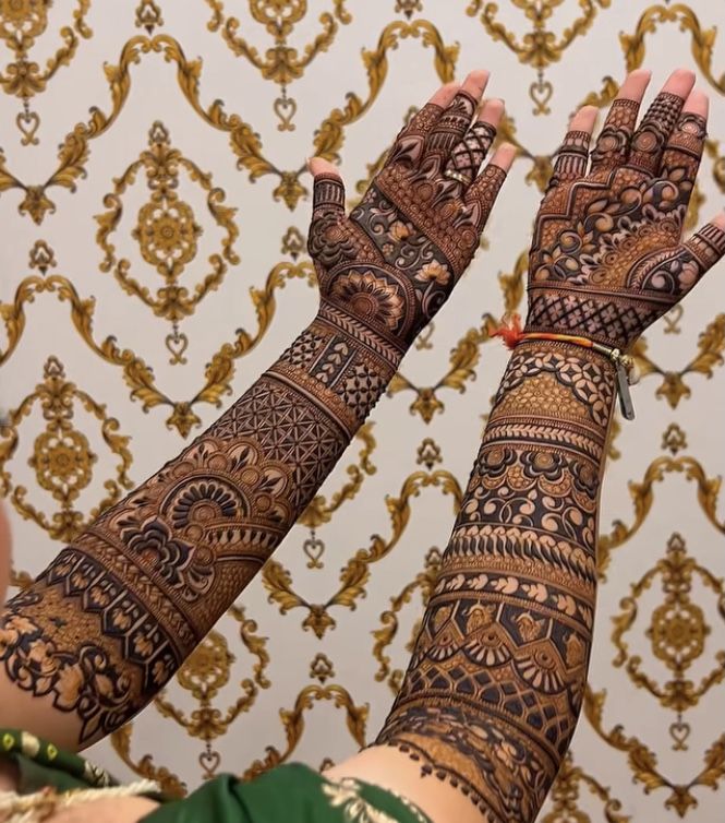 This may contain: two hands with henna tattoos on them