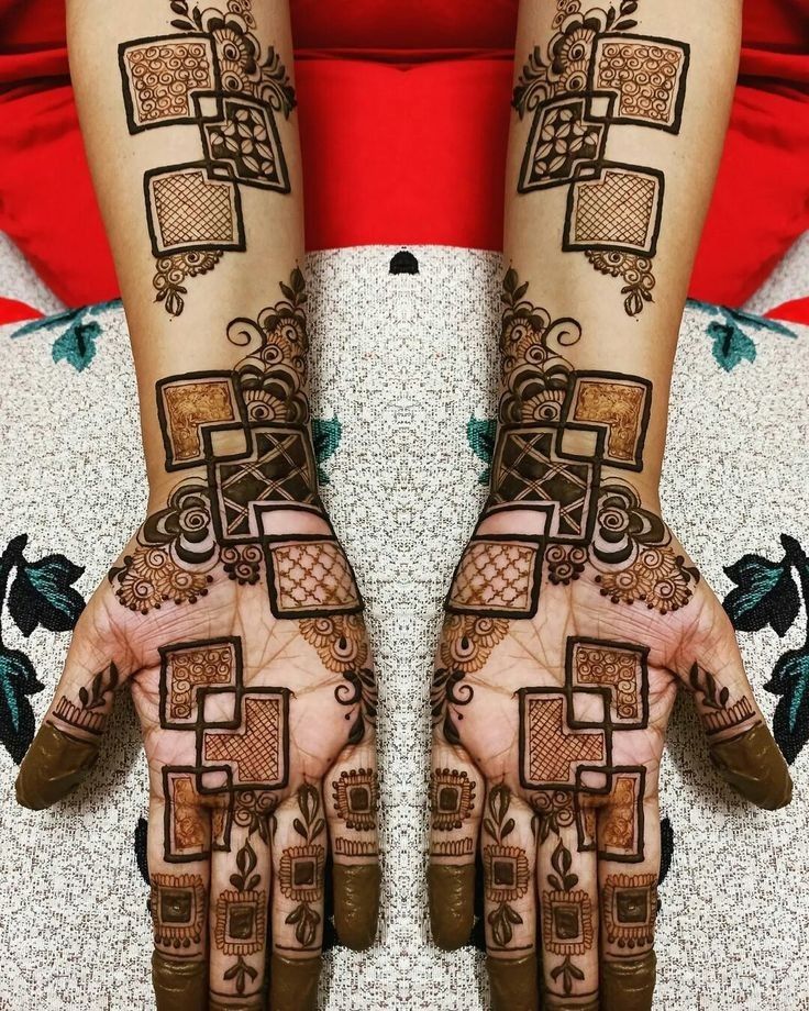 This may contain: two hands with henna designs on them, one is showing the intricate pattern and the other has geometric shapes