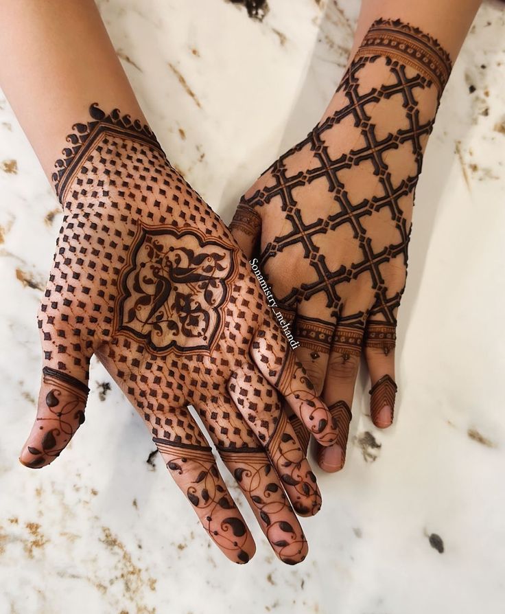 This may contain: two hands with henna designs on them, one is holding the other's hand