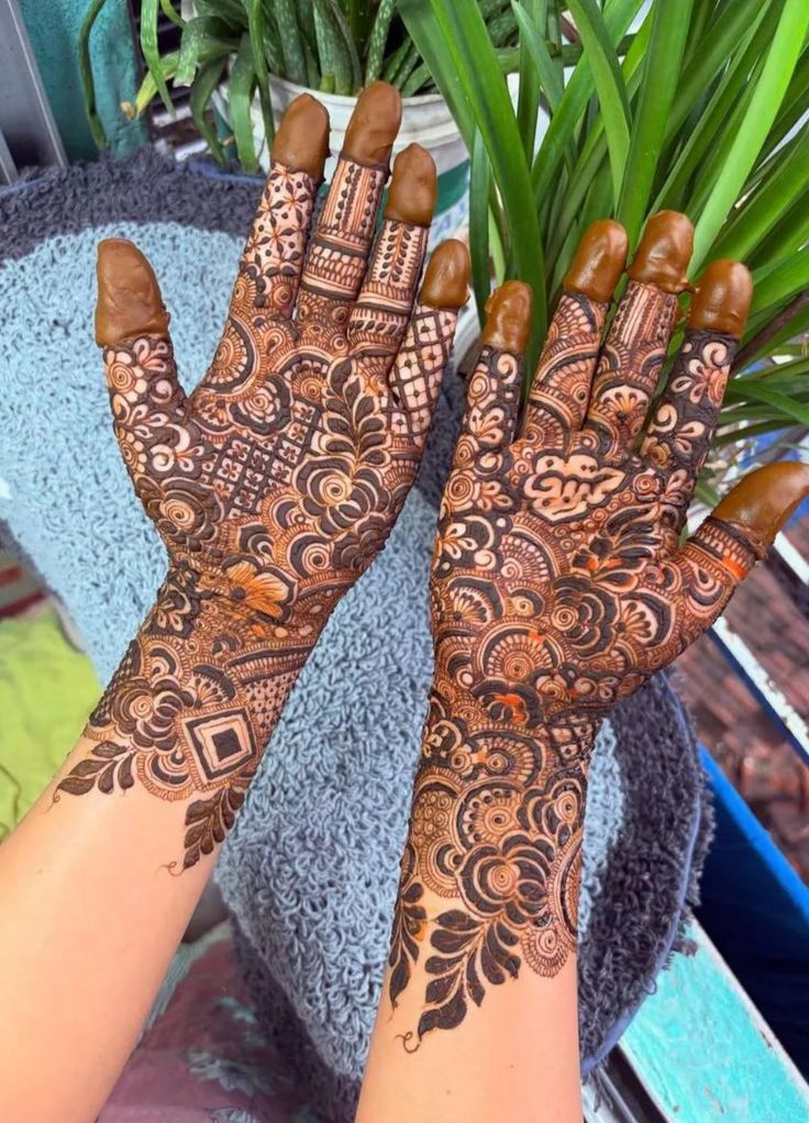 This may contain: two hands with henna designs on them