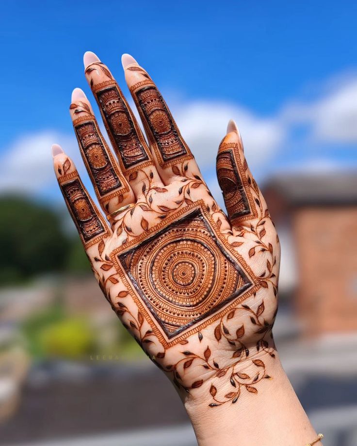This may contain: a woman's hand with henna tattoos on it