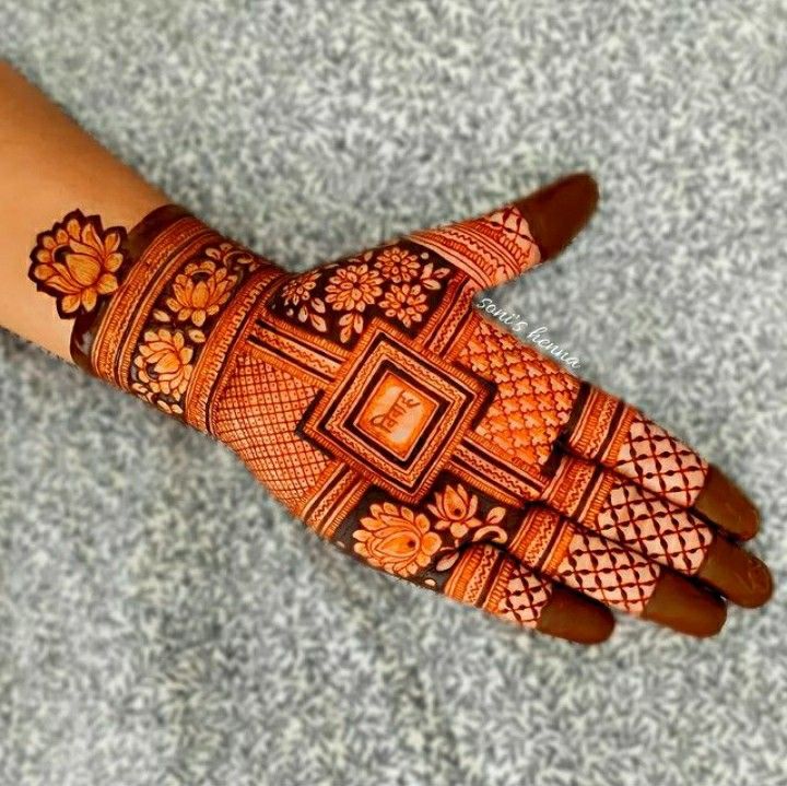 This may contain: a woman's hand with hennap and flowers on the palm, showing her intricate