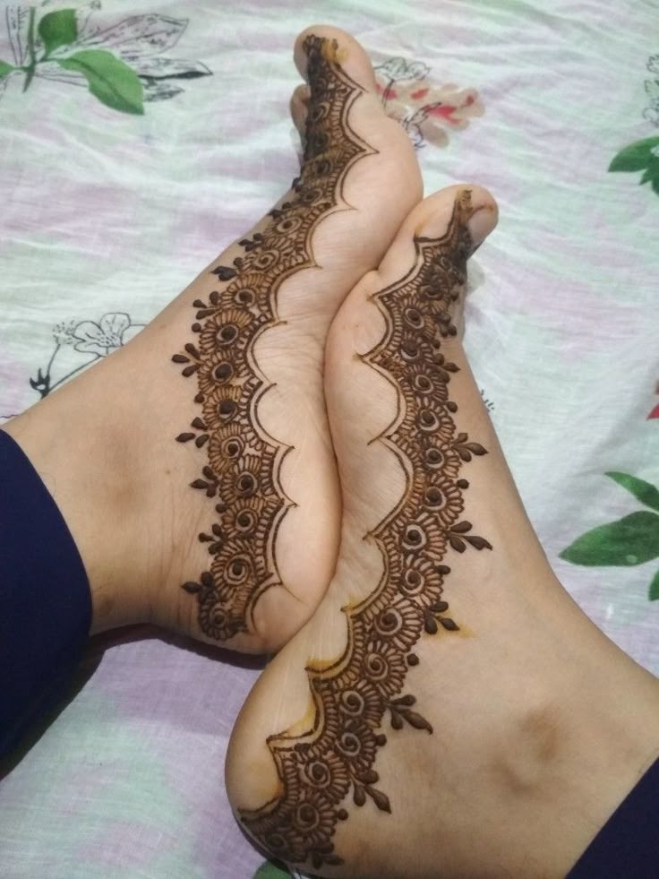 This may contain: two women's feet with hennap on them laying on top of a bed