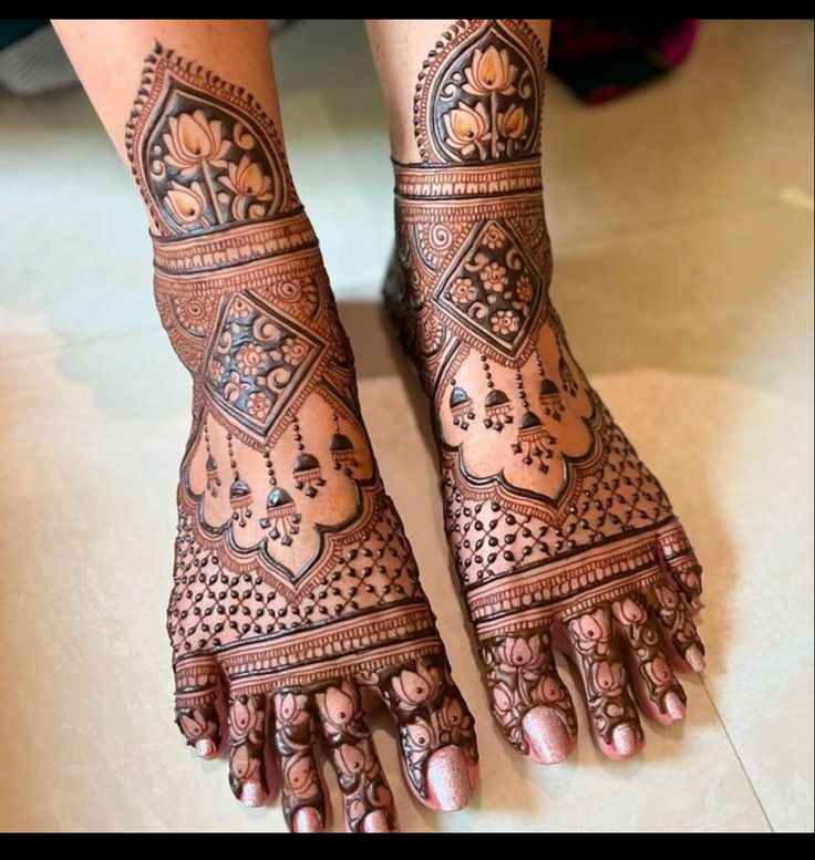 This may contain: the feet and hands of a woman with henna tattoos
