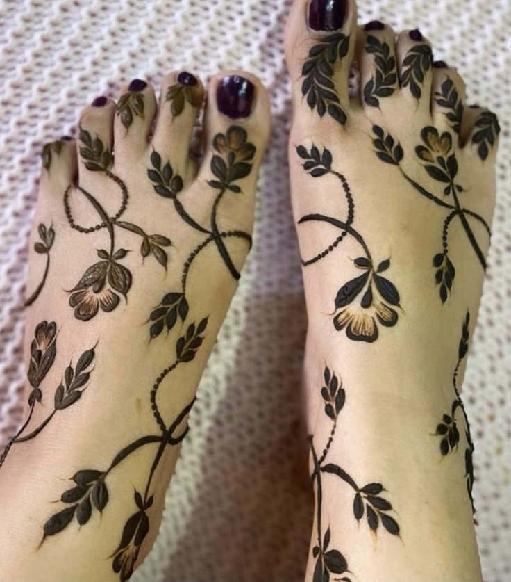 This may contain: a woman's feet with hennap and flowers painted on the bottom part of her legs