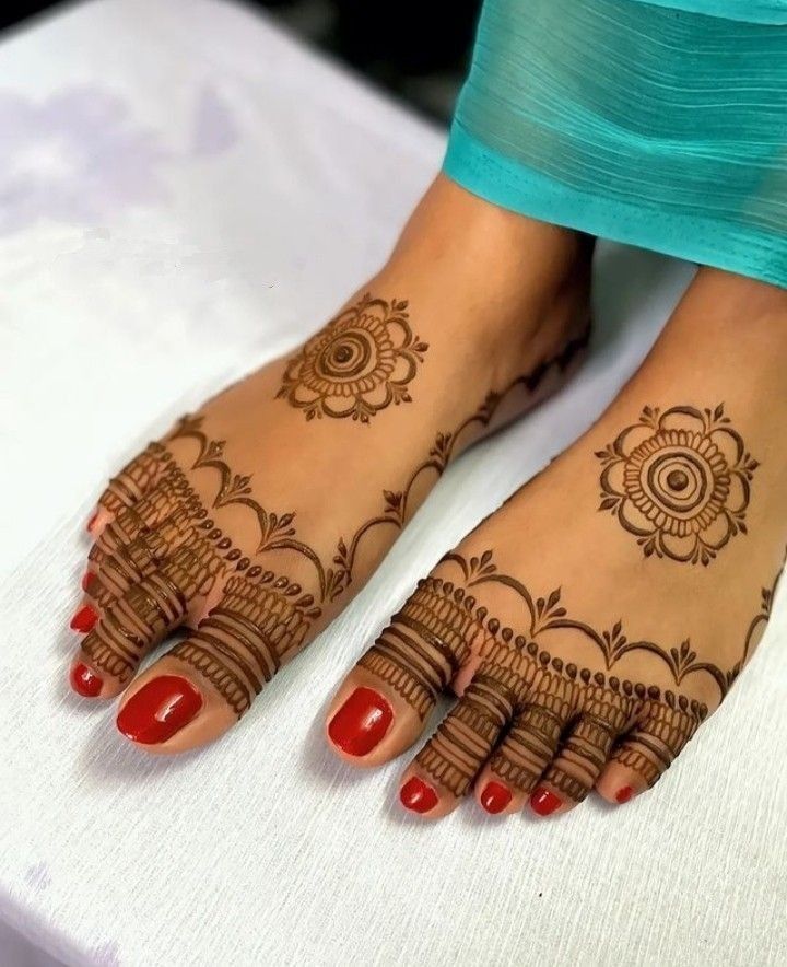 This may contain: a woman's feet with henna tattoos on them