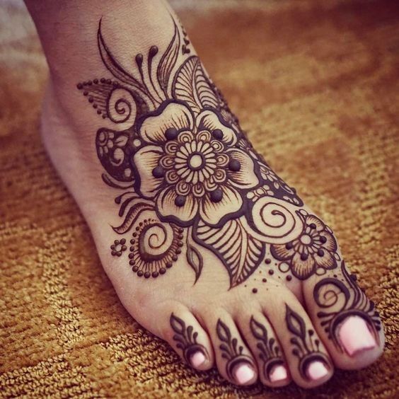 This may contain: the foot is decorated with henna and flowers