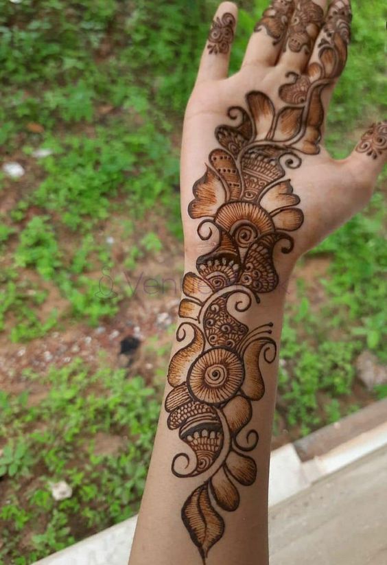 This may contain: the hand is decorated with henna on it