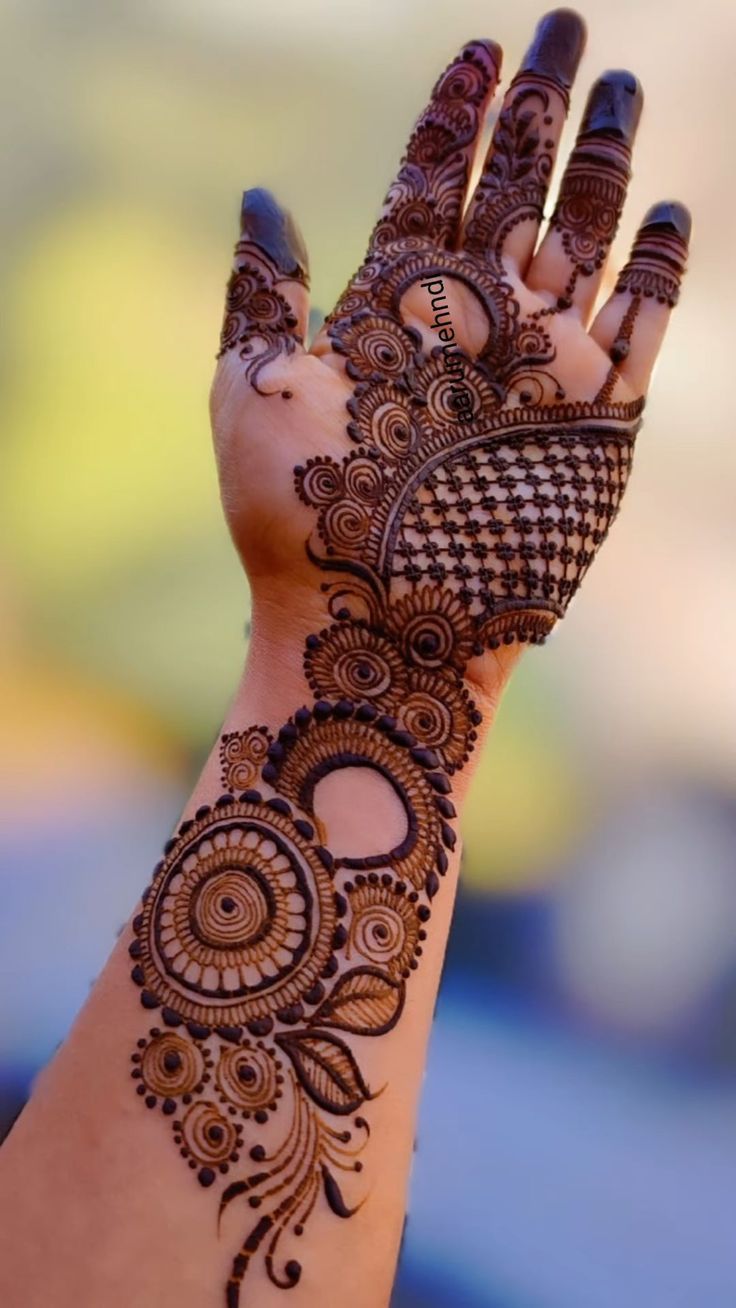 This may contain: the hand is decorated with henna designs