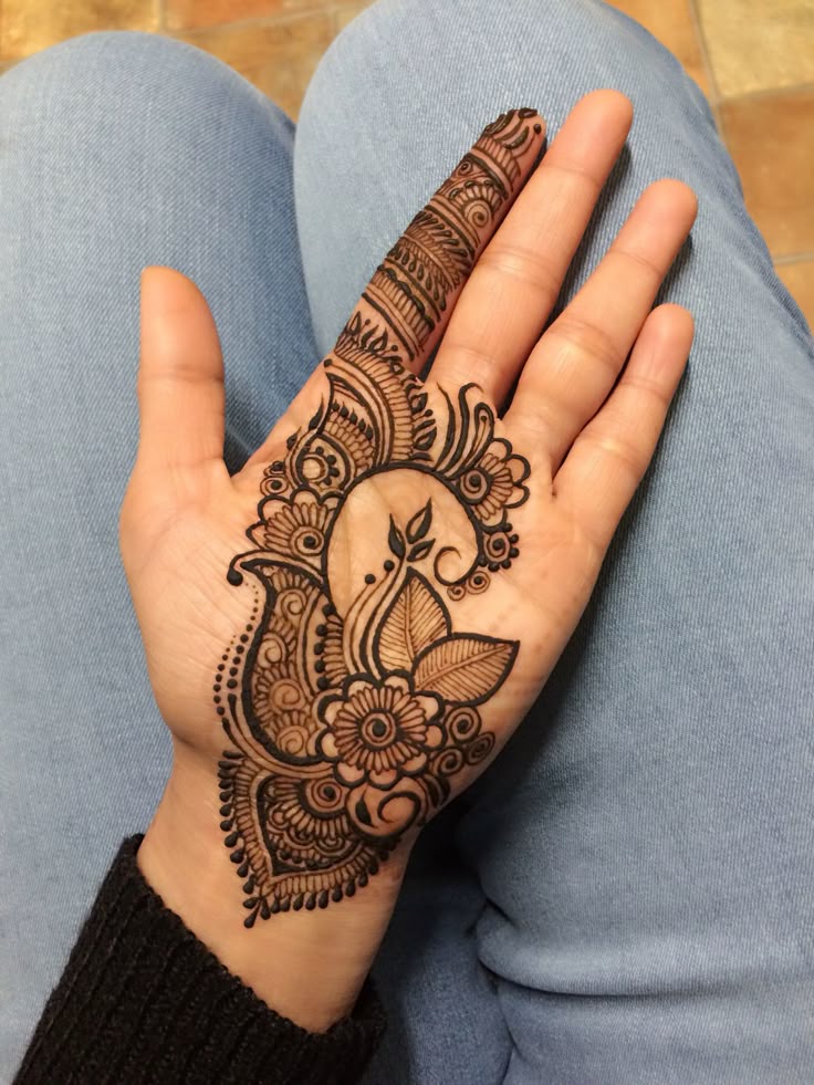 This may contain: a woman's hand with henna tattoos on it