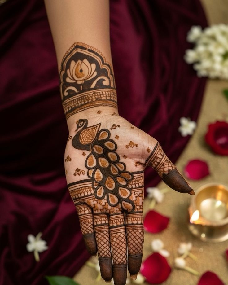 This may contain: a woman's hand with henna on it and flowers in the back ground