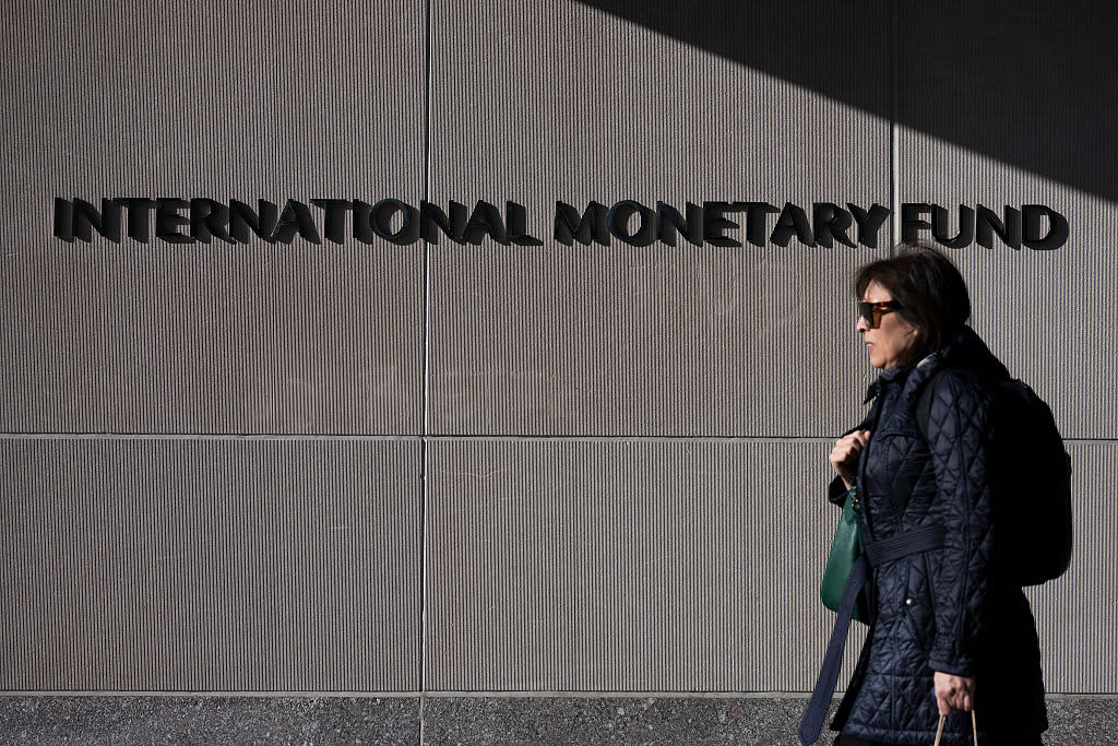 A woman walks past the International Monetary Fund ahead of the International Monetary Fund/World Bank Spring Meetings in Washington, DC, on April 17, 2025. The World Bank and International Monetary Fund's (IMF) Spring Meetings kick off on April 14, with the Bank keen to promote its agenda to drive job creation in developing and emerging market economies. (Photo by Jim WATSON / AFP) (Photo by JIM WATSON/AFP via Getty Images)          
