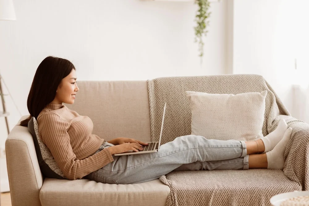 woman-working-on-laptop-on-couch.webp