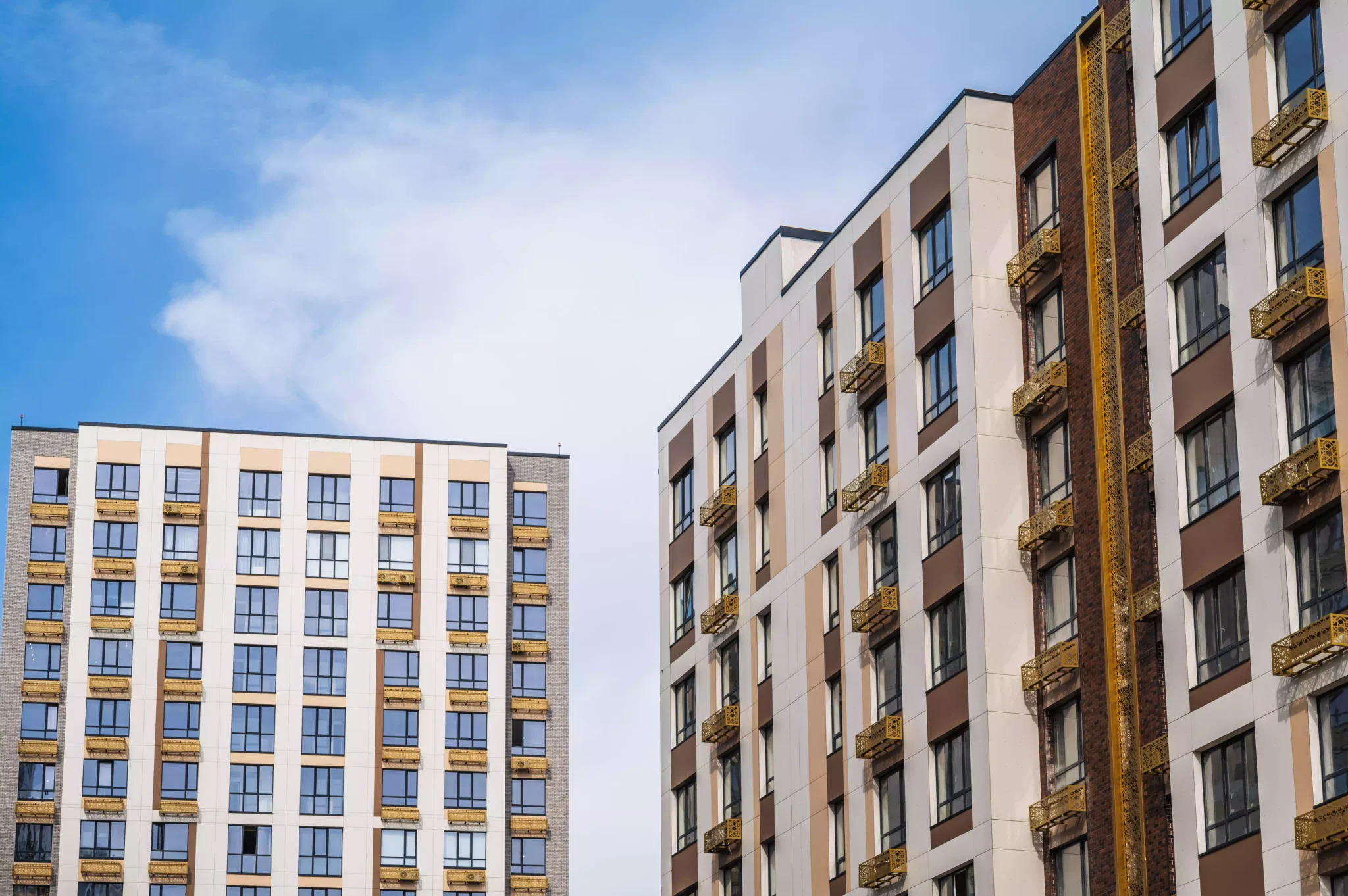 modern-apartment-buildings-against-a-blue-sky-2026-09-23-01-43-35-utc-min-2048x1362.webp
